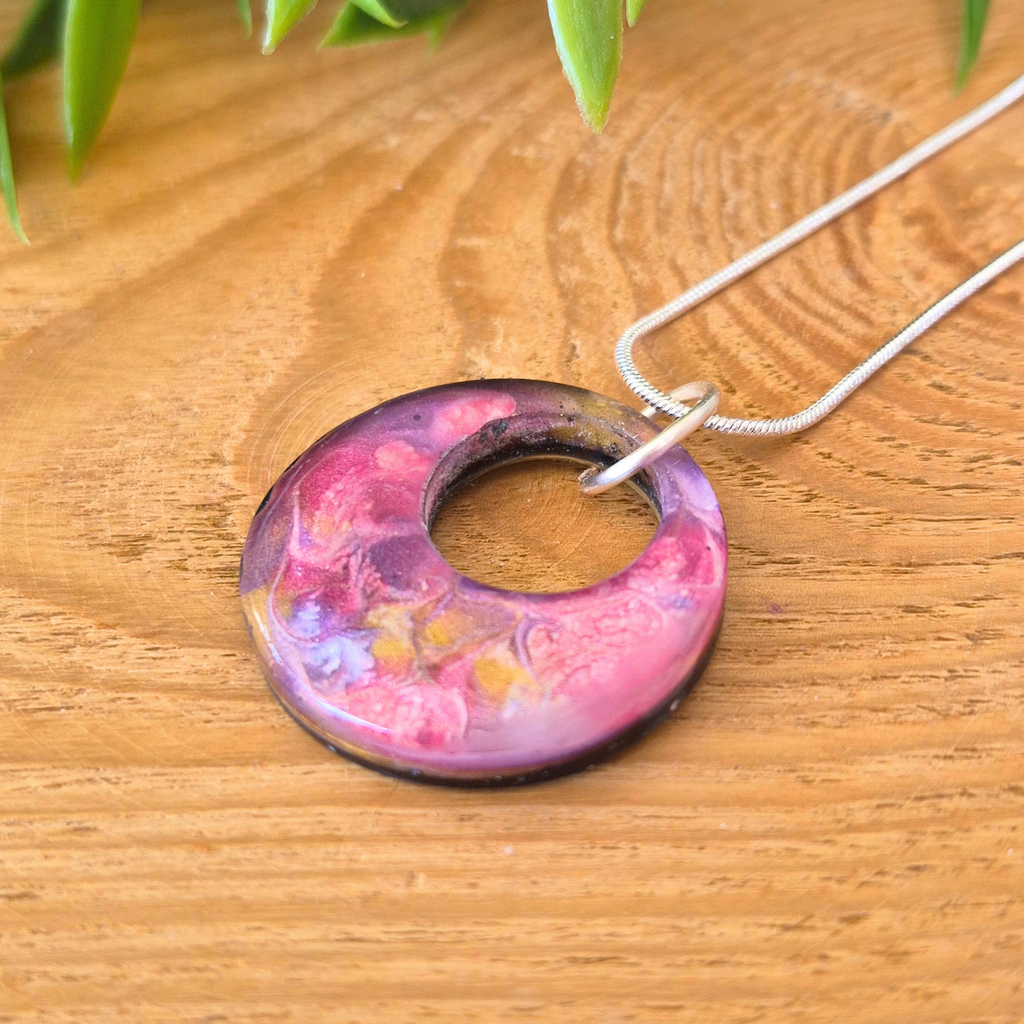 Necklace with a colorful pendant on a wooden surface