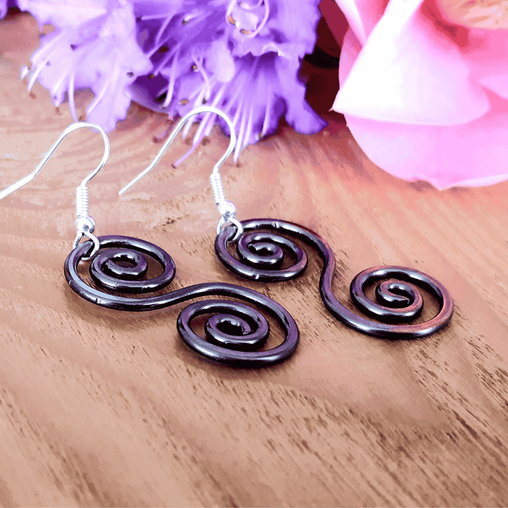 Boho copper Celtic earrings on a wooden surface