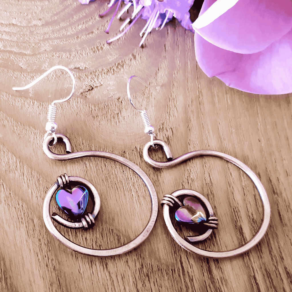 Rainbow hematite heart hoop copper earrings on light wood background, handmade copper jewellery UK