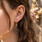 Open spiral copper earrings worn by model, handmade boho drop earrings UK