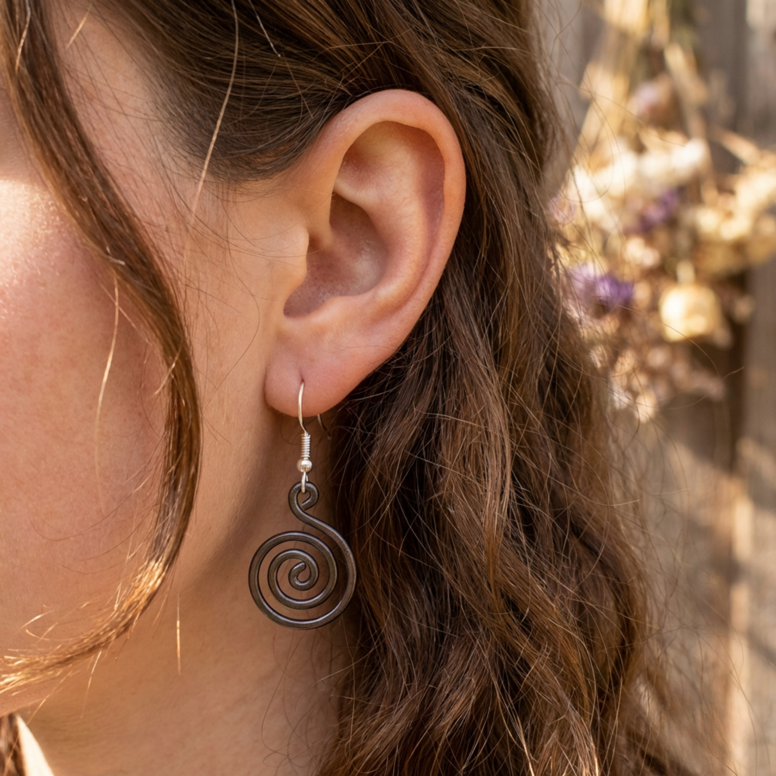 Open spiral copper earrings worn by model, handmade boho drop earrings UK
