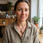 Woman wearing a necklace with a unique design in an indoor setting