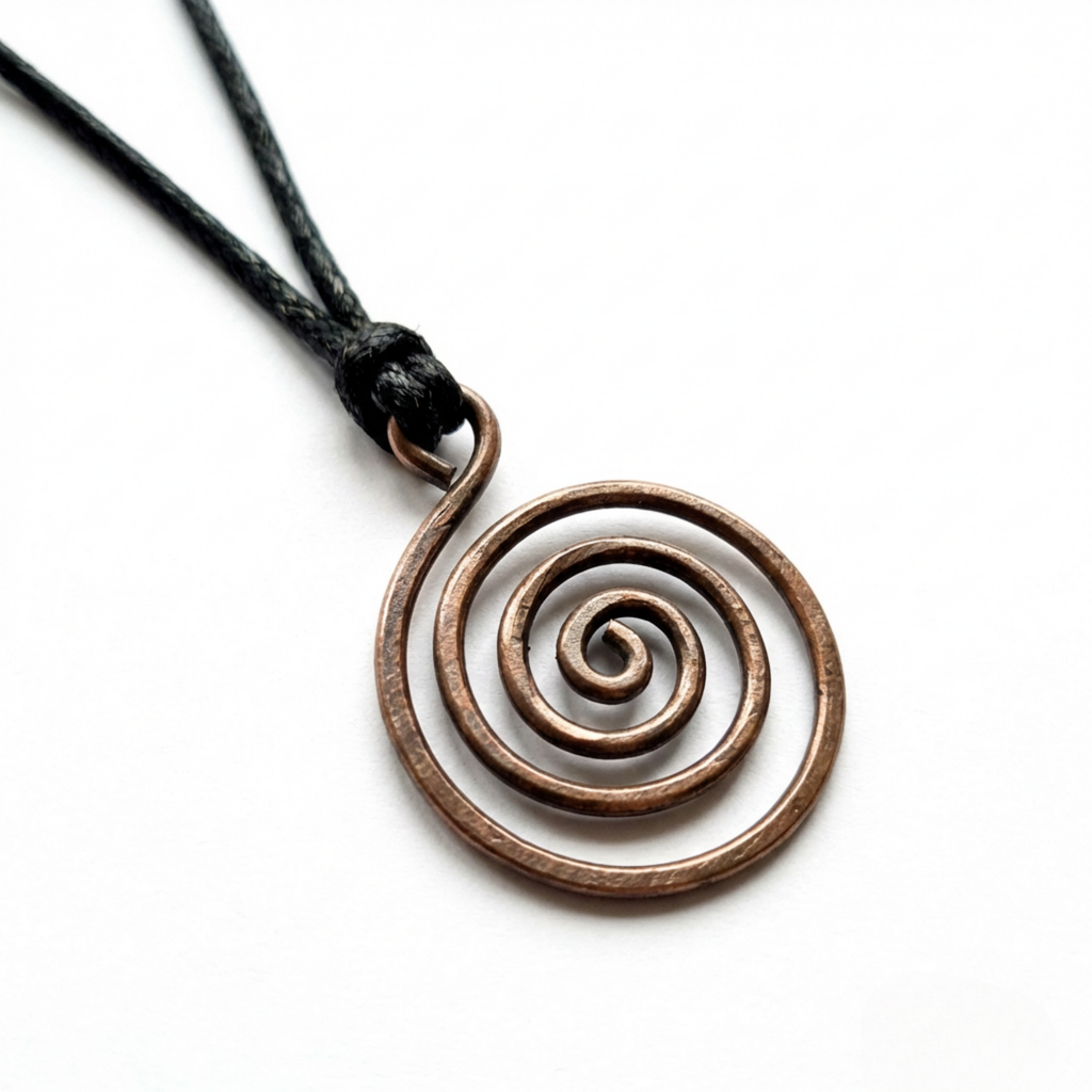 Copper spiral pendant on a black cord against a white background