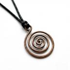 Copper spiral pendant on a black cord against a white background
