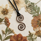 Decorative pendant with a floral and leaf arrangement on a textured surface