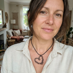 Woman wearing a heart-shaped necklace in a living room setting