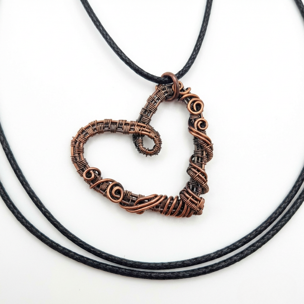 Wire weave spiral copper heart pendant on a white surface