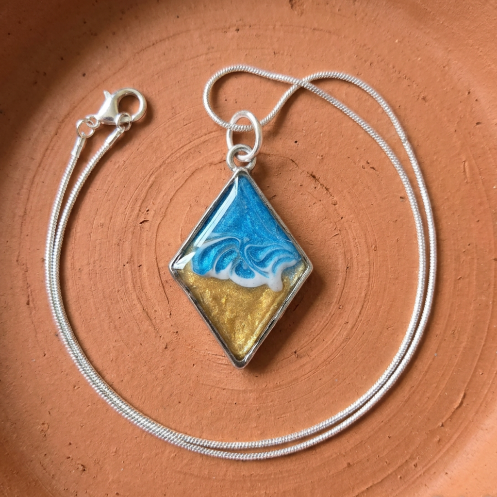 Necklace with a diamond-shaped pendant featuring blue and gold design on a brown surface