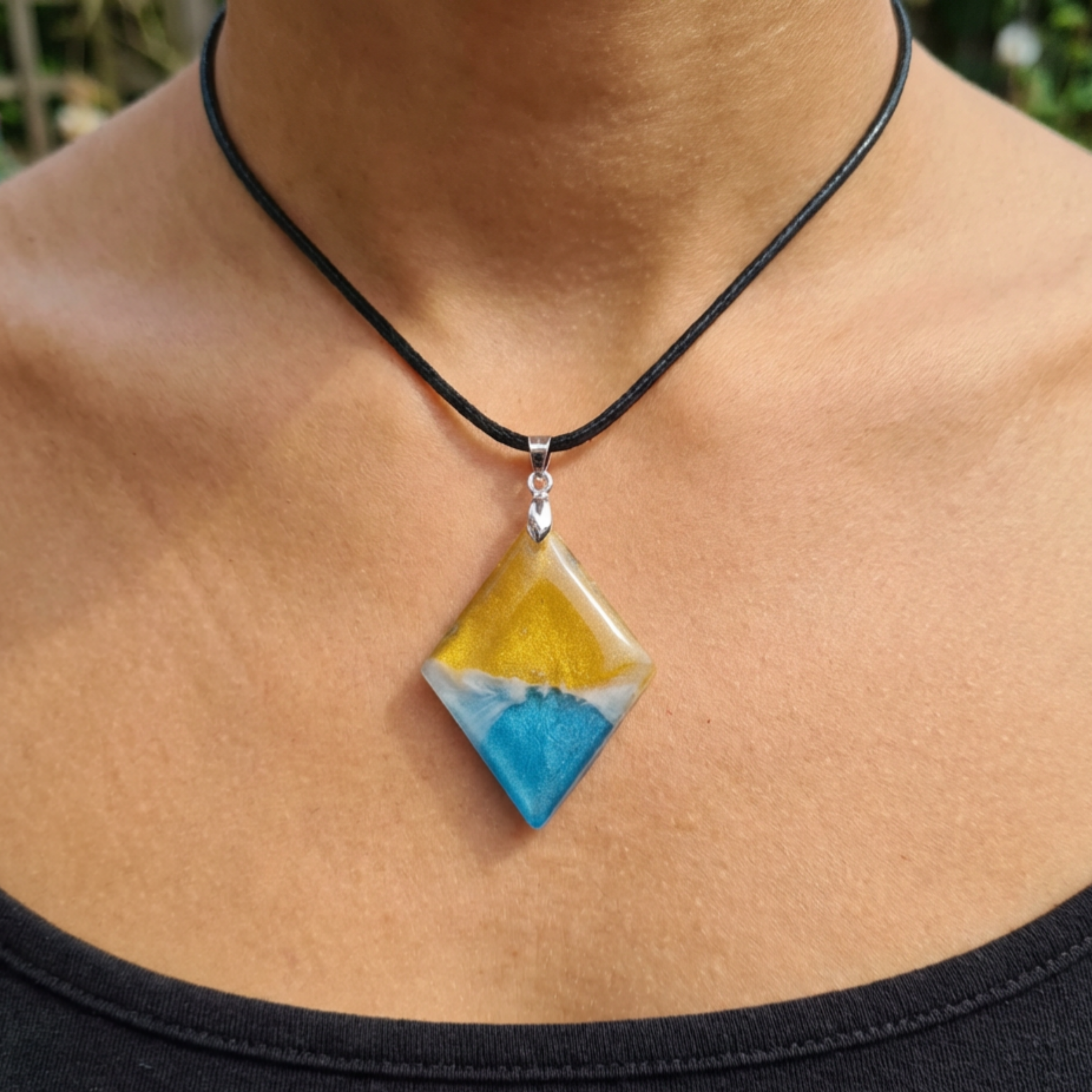 Necklace with a yellow and blue pendant on a person's neck