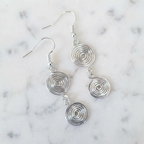 Silver spiral earrings on a marble background