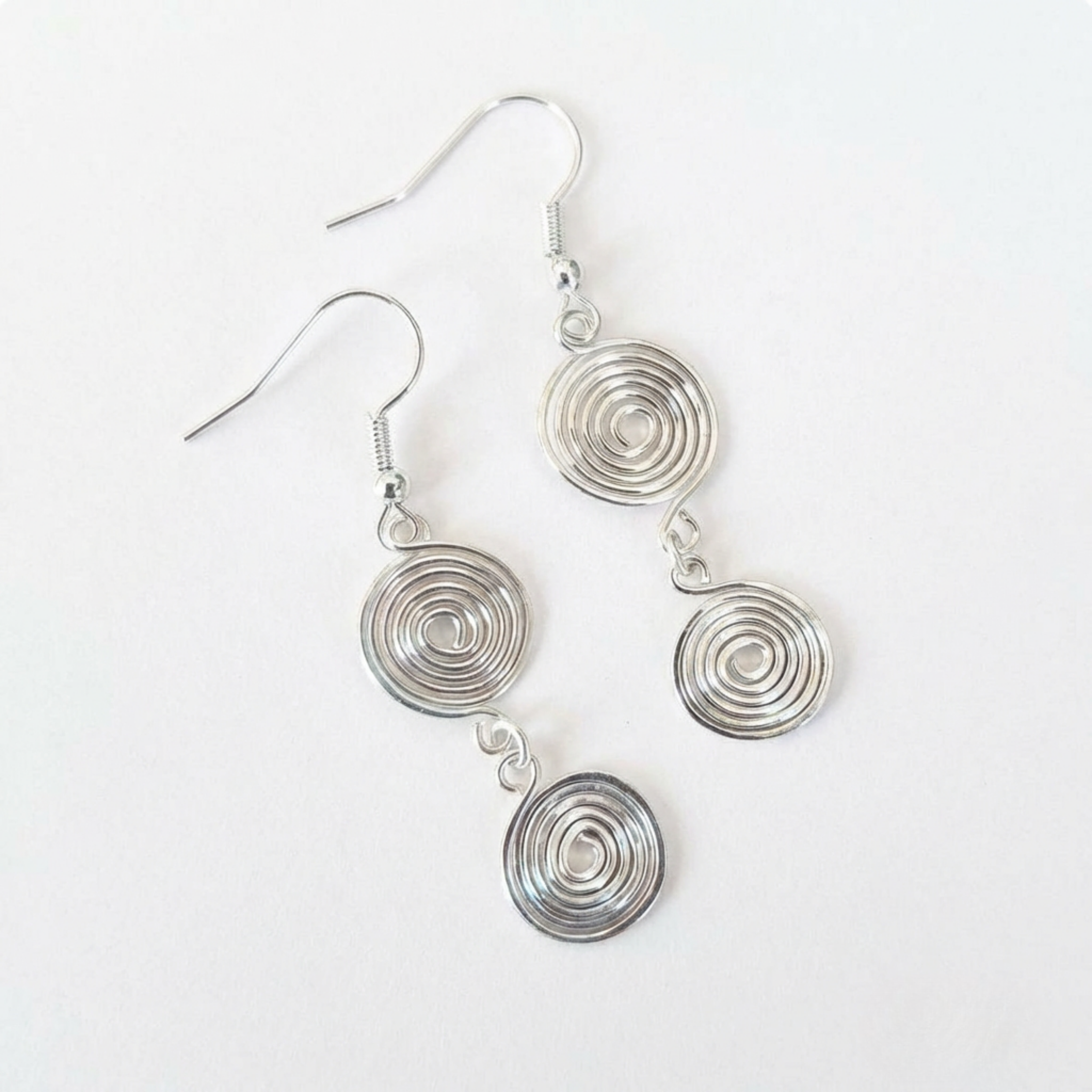 Silver spiral earrings on a white background