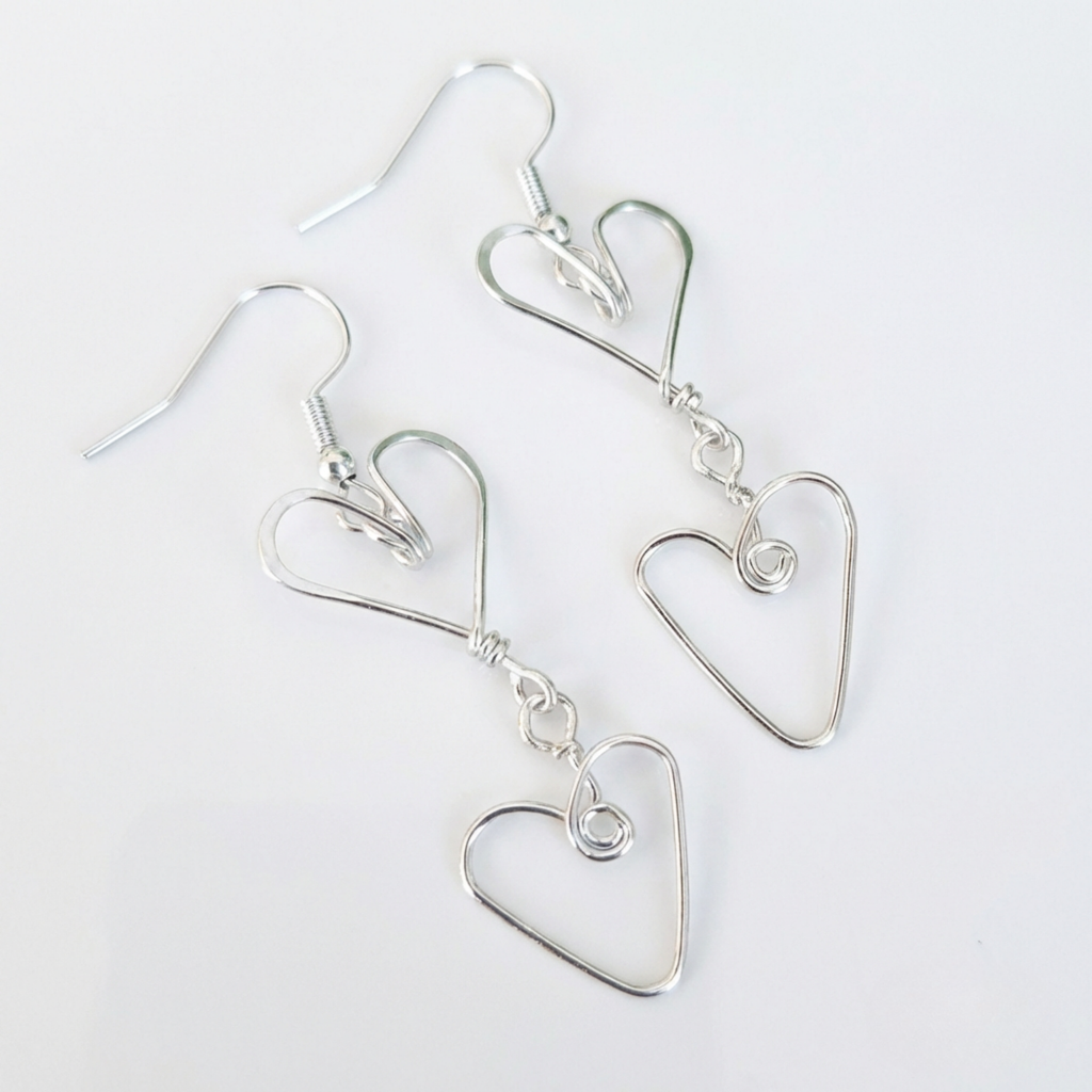 Silver heart-shaped earrings on a white background