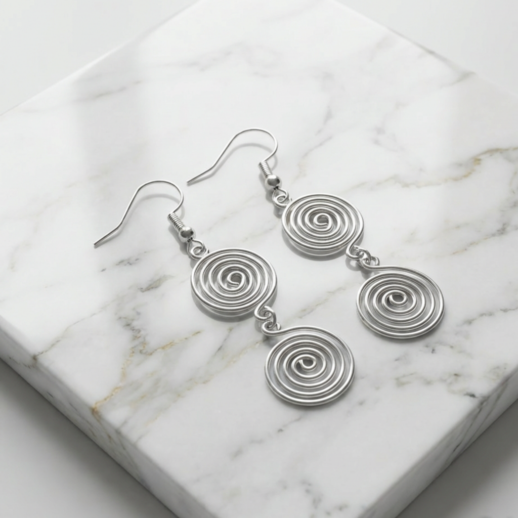 Silver spiral earrings on a marble surface