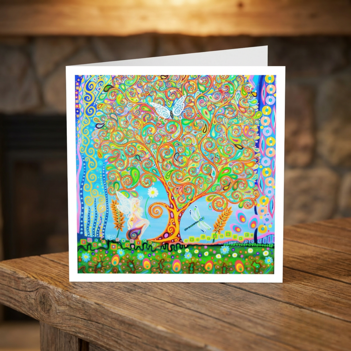 Colourful abstract artwork greeting card on a wooden surface with a blurred background