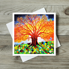 Colourful tree design on a greeting card with a white envelope on a wooden surface