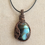 Necklace with a Labradorite stone pendant on a beige fabric background