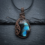 Necklace with a pendant featuring a blue stone on a dark background