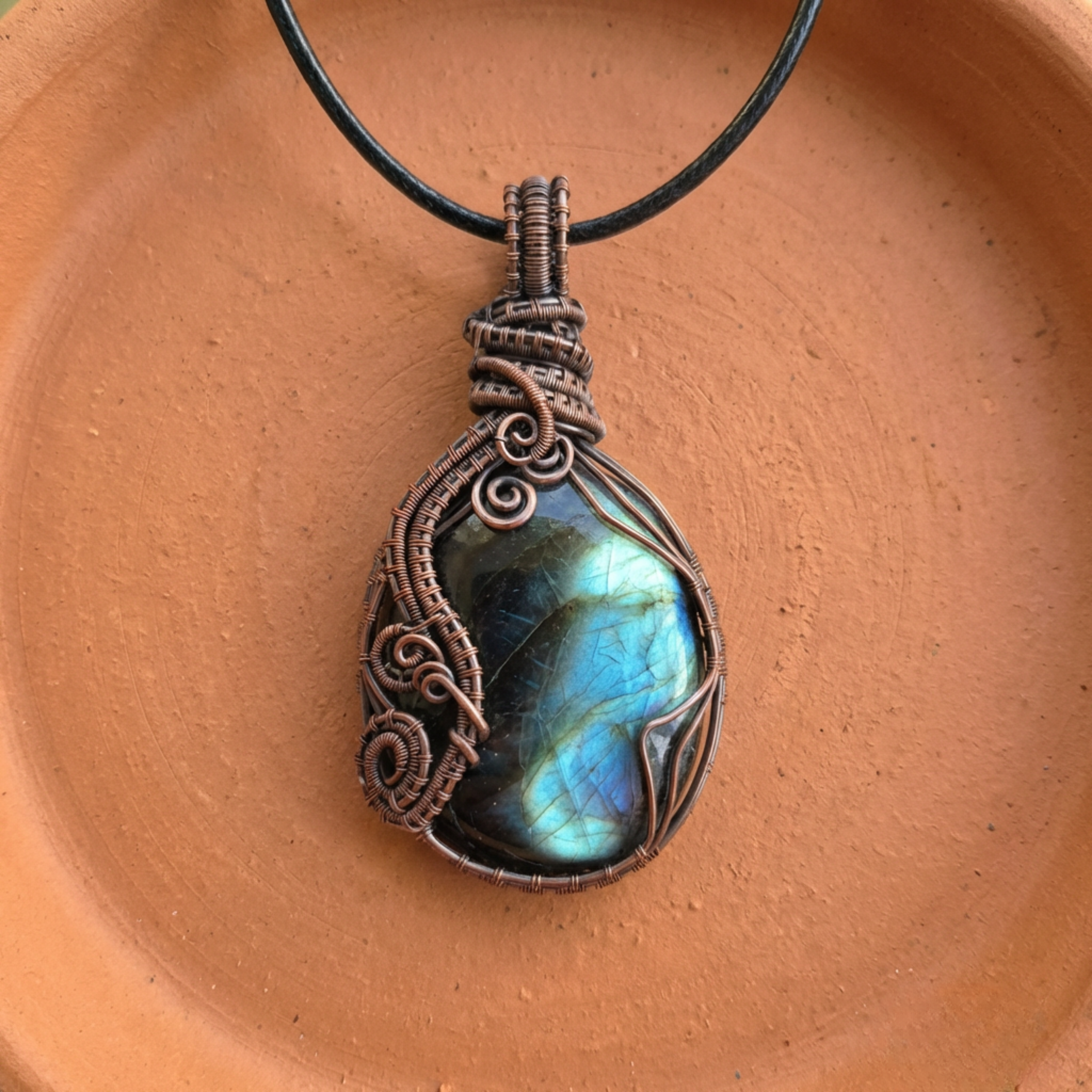 Necklace with a Labradorite pendant on a terracotta surface