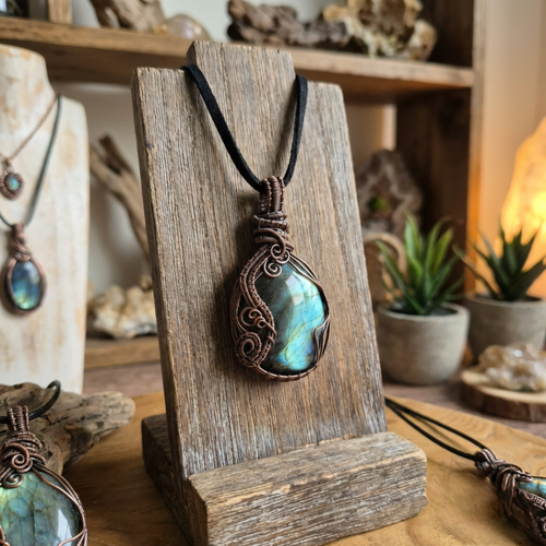 Necklace with a pendant on a wooden stand, surrounded by decorative items.
