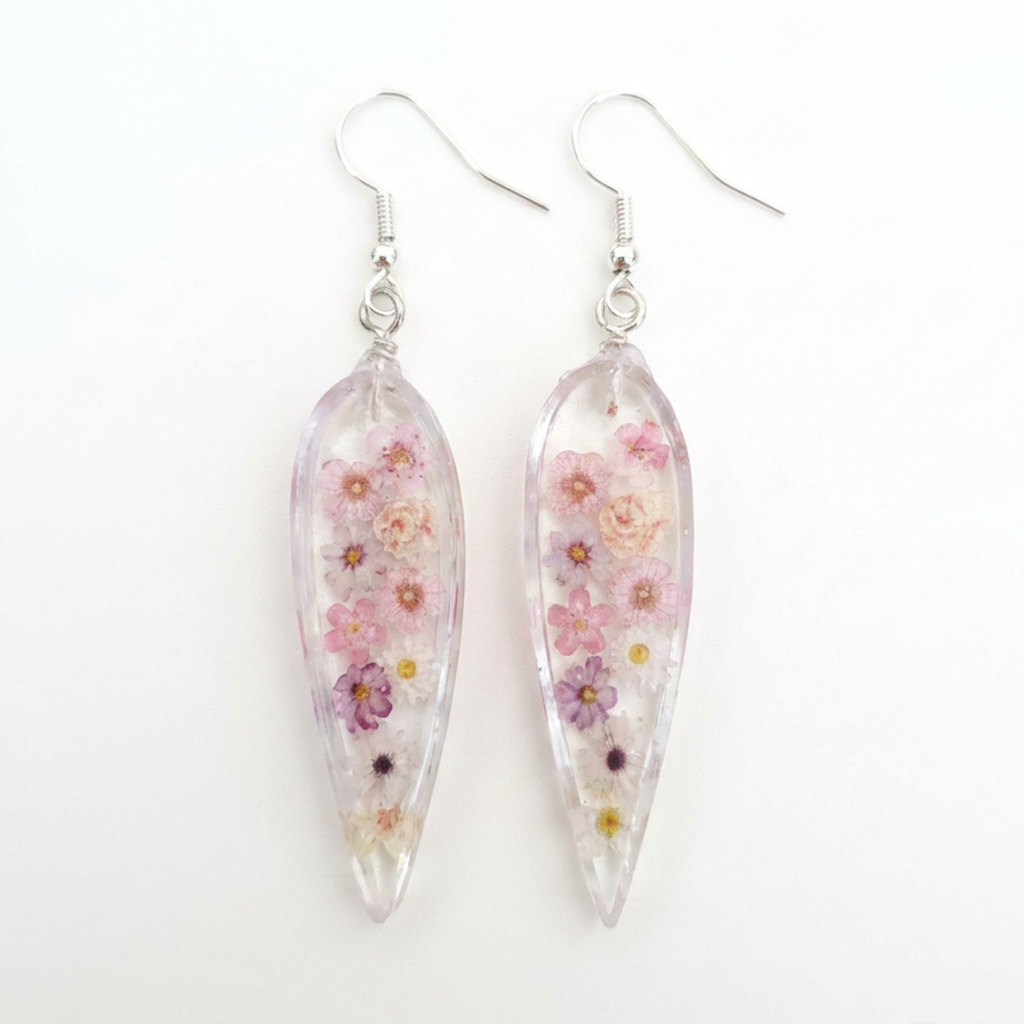 Teardrop-shaped earrings with floral design on a white background