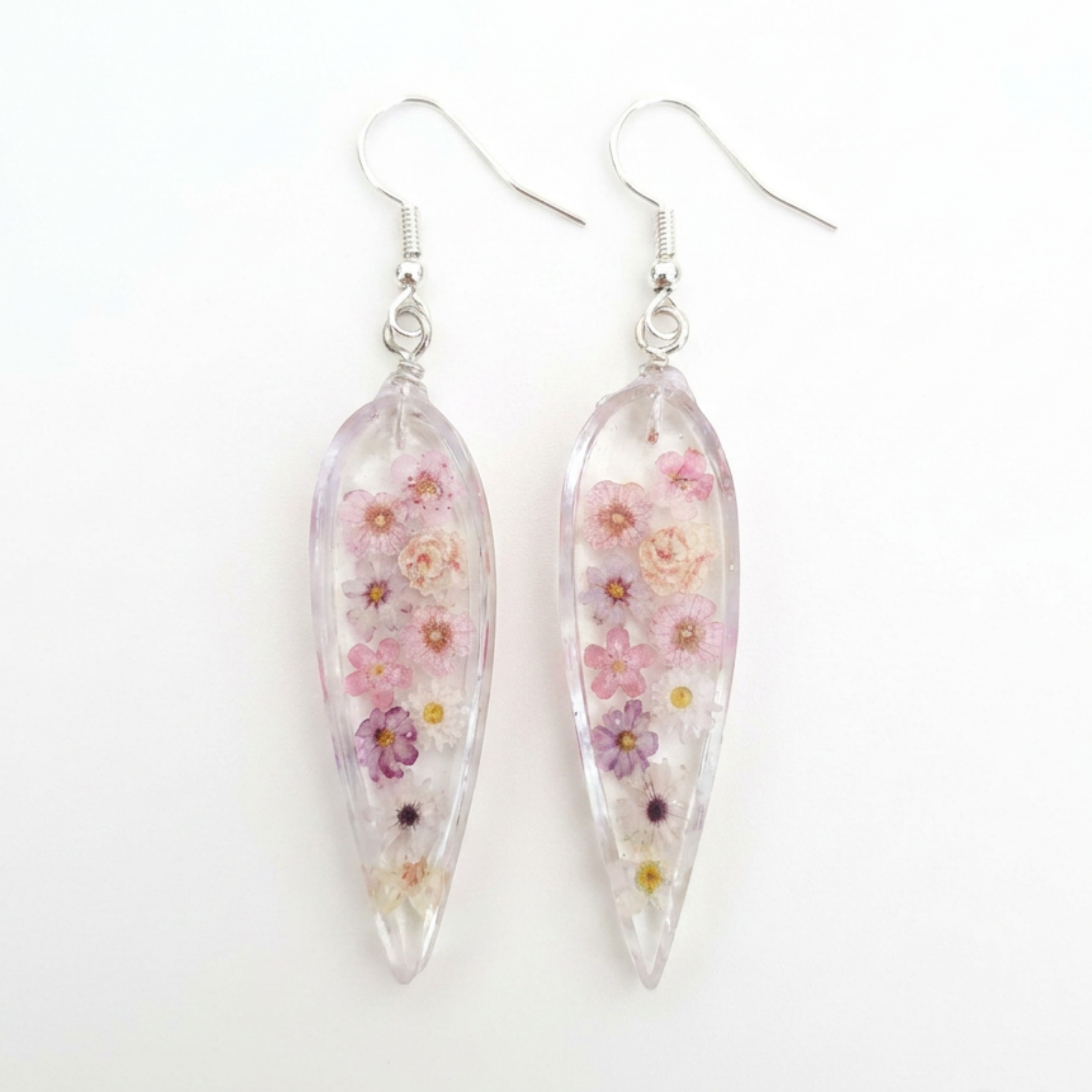 Teardrop-shaped earrings with floral design on a white background