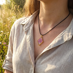 model wearing a diamond gold bezel with a suspended pink flower