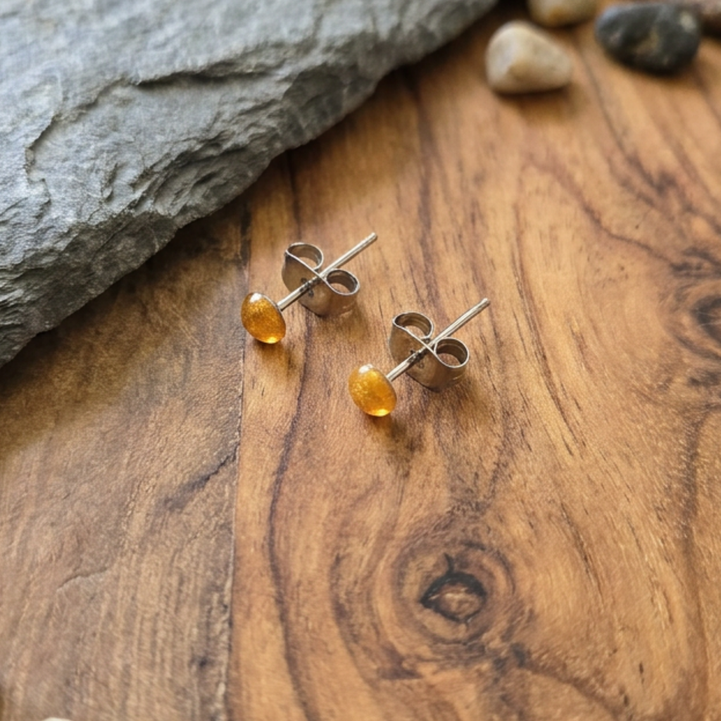 Silver stud earrings with  stones on a wooden surfaceold
