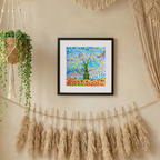 Framed colourful artwork of a tree of life and flowers on a wall with decorative elements.
