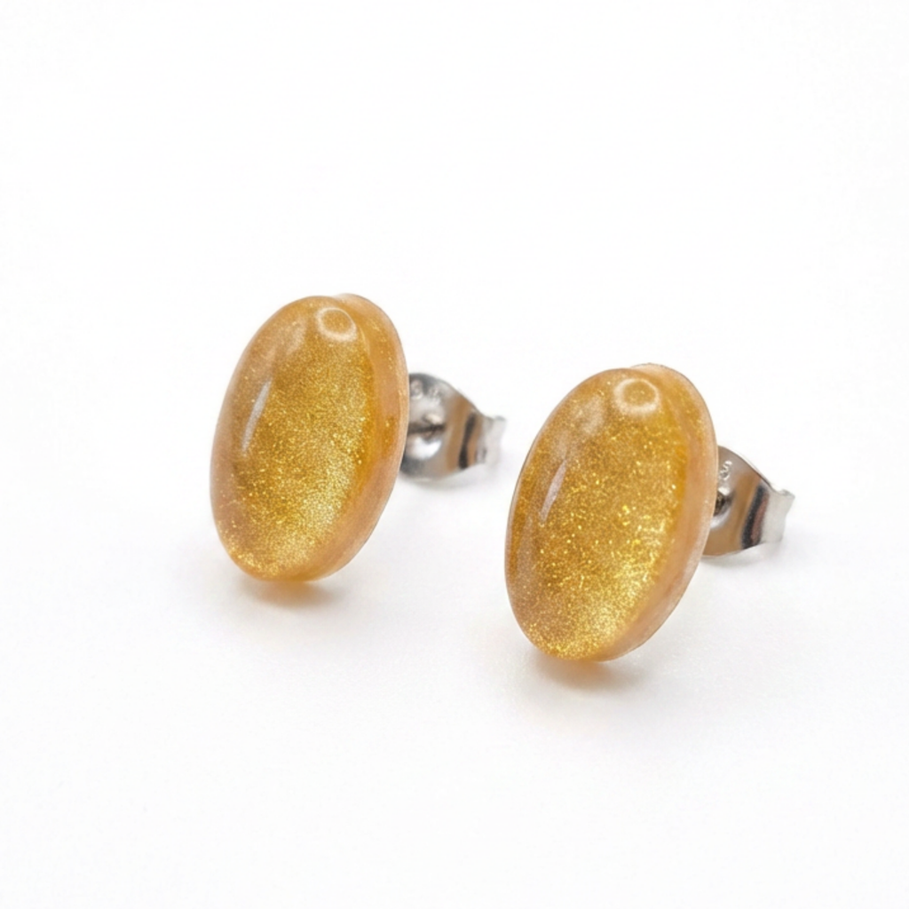 Simple gold oval stud earrings on a white background