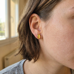 female model wearing a gold oval stud earrings