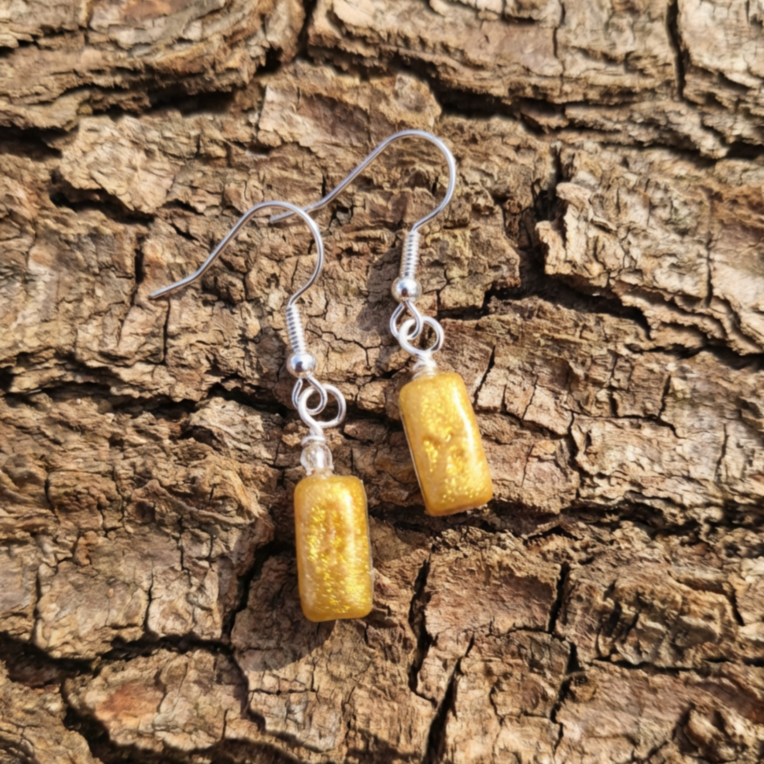 Rectangle gold drop earrings on bark