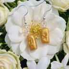 Pretty gold rectangle drop earrings on a flower