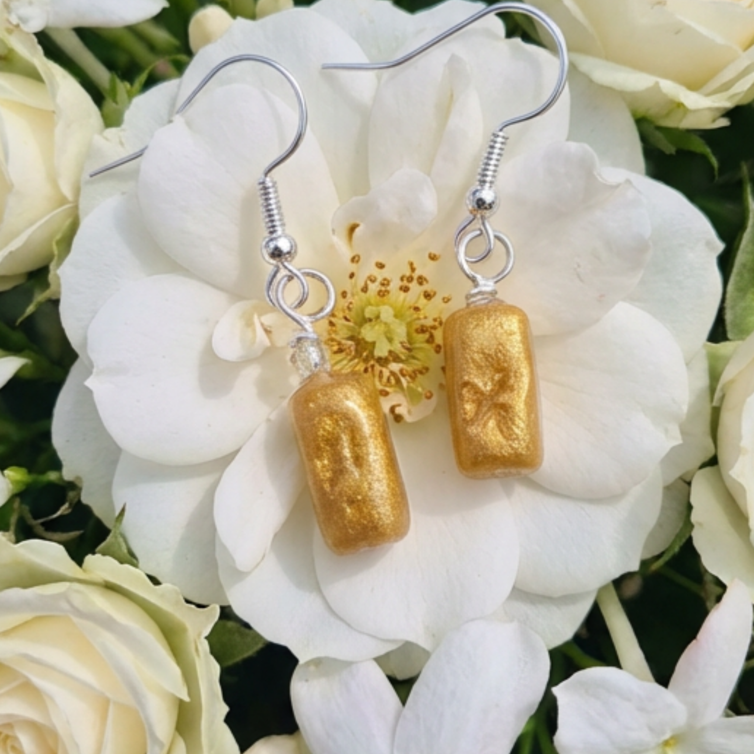 Pretty gold rectangle drop earrings on a flower