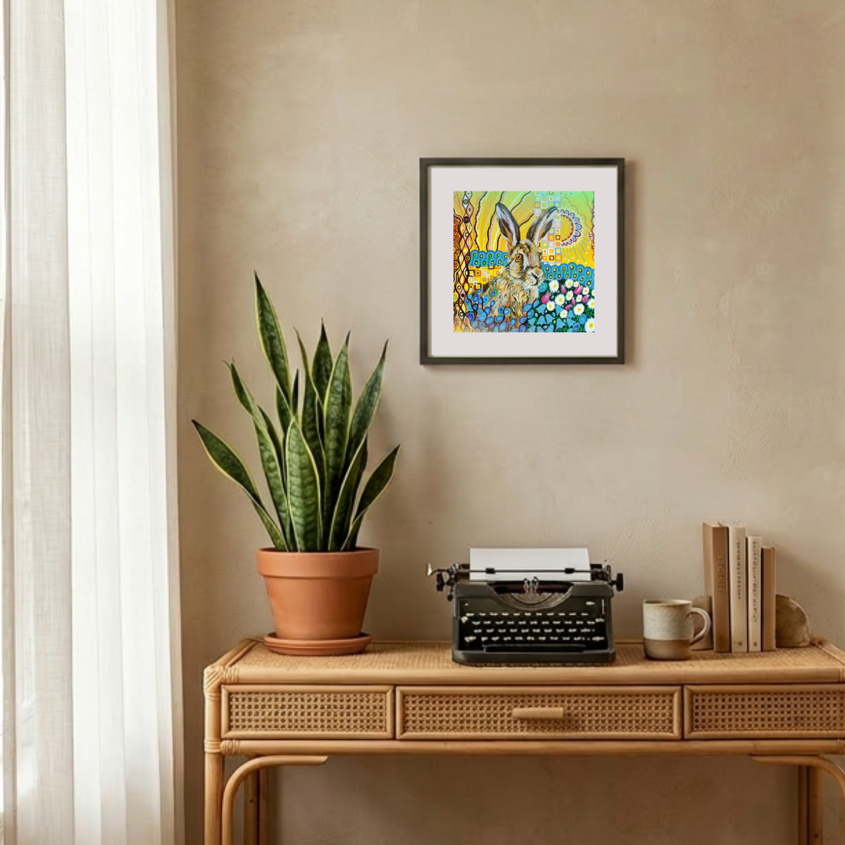 Decorative setup with a potted plant, typewriter, and framed artwork on a beige wall.