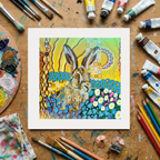 Colourful artwork of a rabbit on a wooden surface with art supplies.