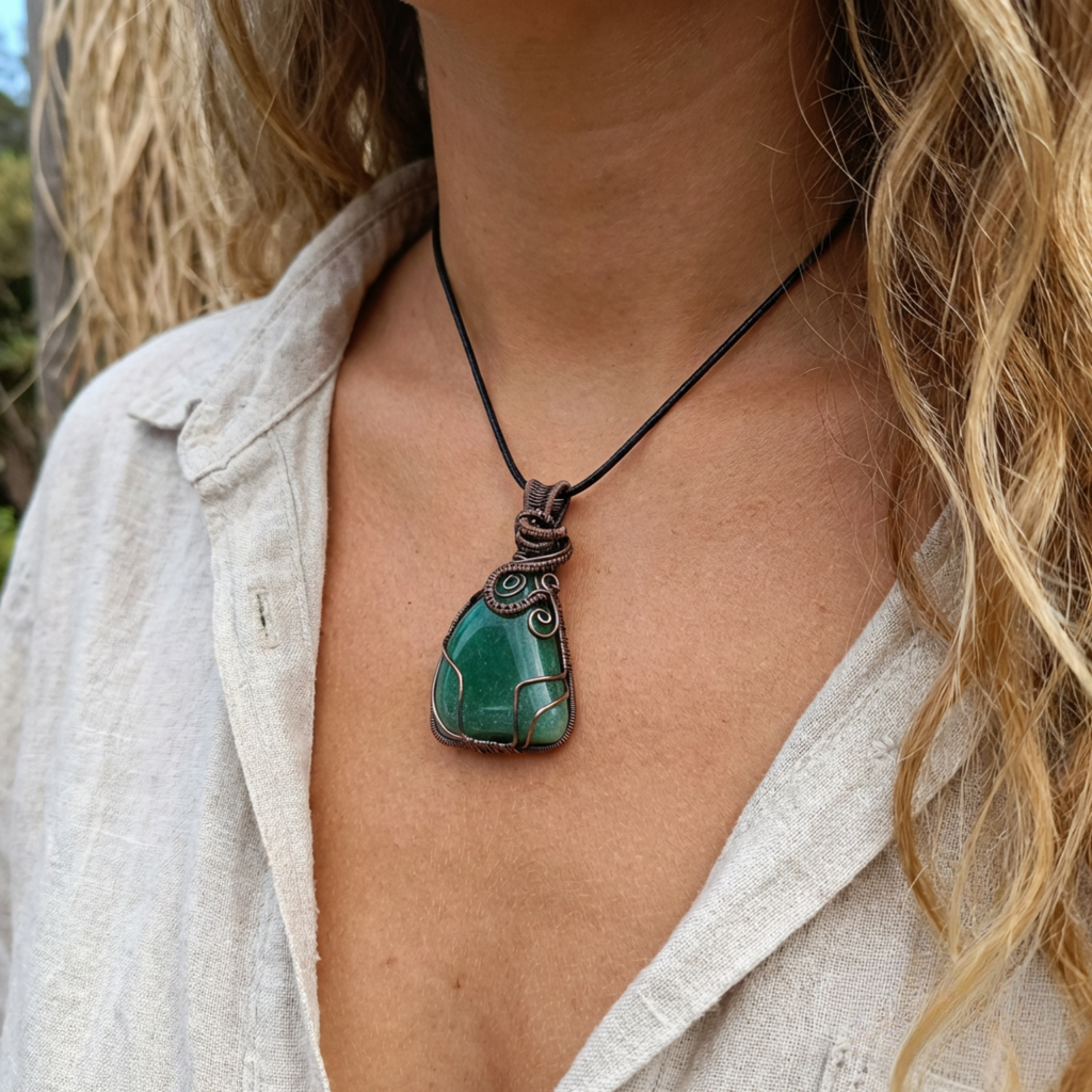 Person wearing a necklace with a green pendant outdoors