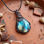 Labradorite pendant necklace on a rustic background with dried plants