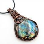 Labradorite pendant with copper wire wrapping on a white background