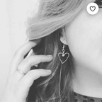 Heart-shaped earring worn by a person with hair covering part of their face