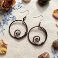 Hoop copper spiral earrings flat lay, handmade boho hoop earrings UK