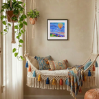 Decorative indoor swing with colourful pillows and a framed hot air balloon artwork on the wall.