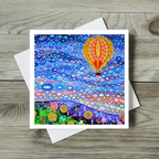 Colourful greeting card with a hot air balloon design on a wooden surface