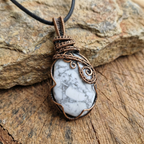 Necklace with a white howlite stone pendant on a wooden surface