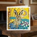 Colourful greeting card with a hare illustration on a wooden surface
