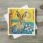 Greeting card with a colorful rabbit illustration on a wooden surface