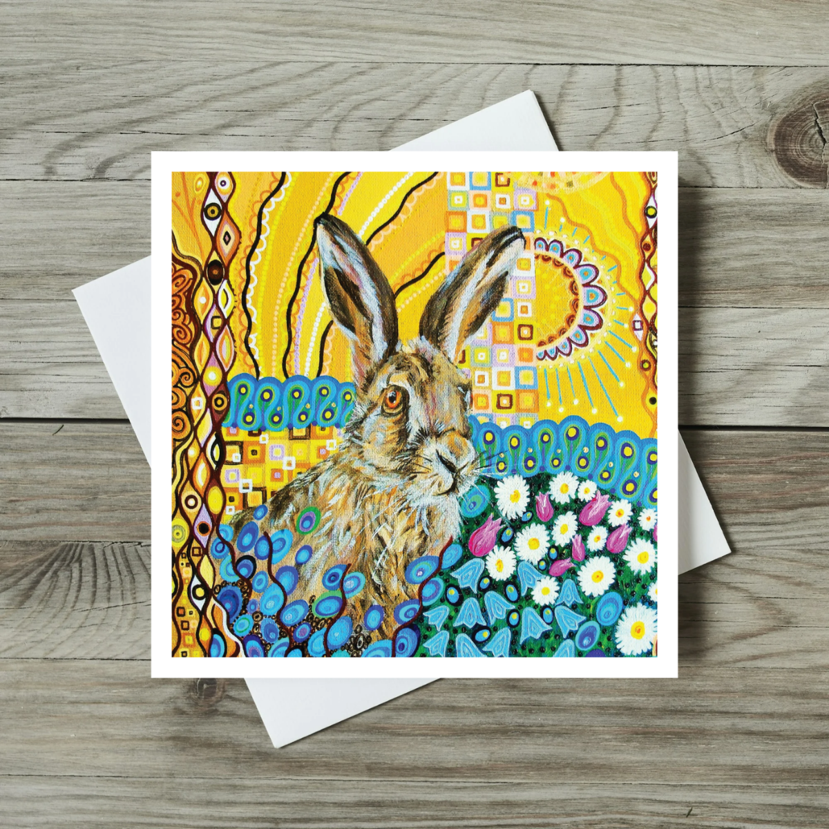 Greeting card with a colorful rabbit illustration on a wooden surface