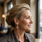Woman with styled hair and earrings in a blurred indoor setting