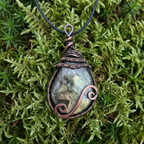 Necklace with a pendant on a green moss background