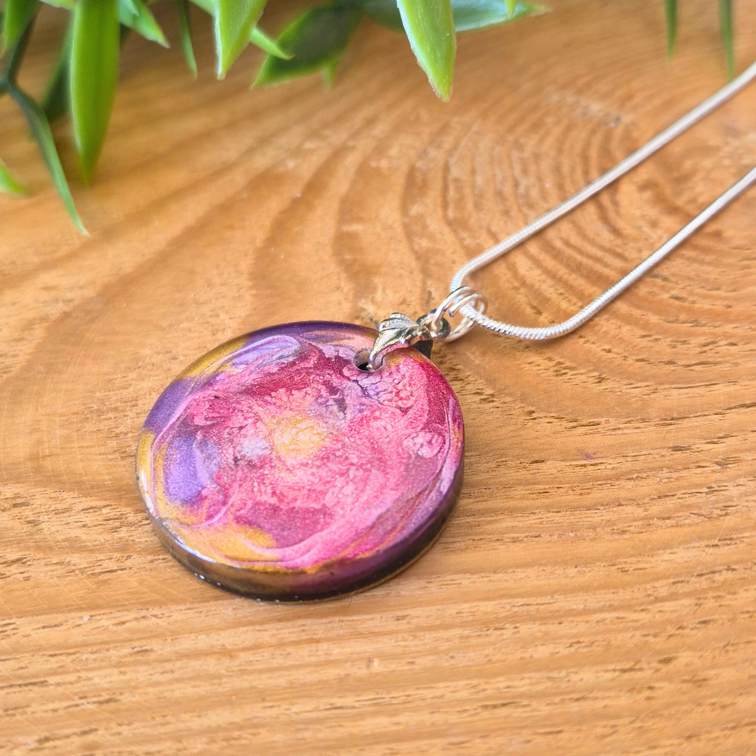 Necklace with a colorful pendant on a wooden surface