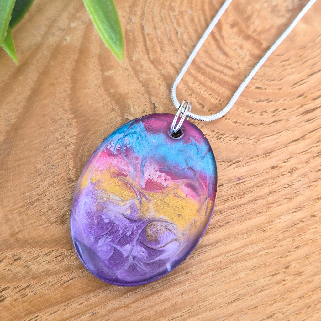 Colorful marbled pendant on a wooden surface
